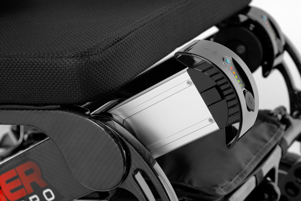 Porto Mobility Ranger SpacePro XXL folding power wheelchair, silver pack with indicator lights under the seat close up